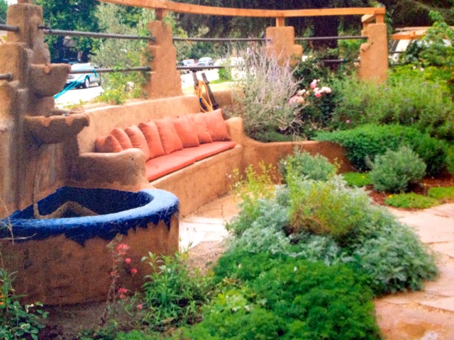 Backyard sitting area among shrubs and a fountain.